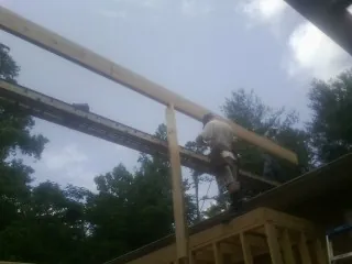 Carpenter setting a ridge beam over a new addition frame — Ice Dam Removal by Roofing Brothers in Schuylerville