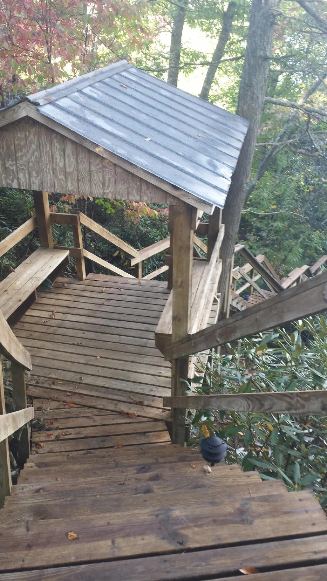 Metal roofed shelter over wooden steps on a wooded walkway — Skylight Repair & Installation work by our crew in Schuylerville