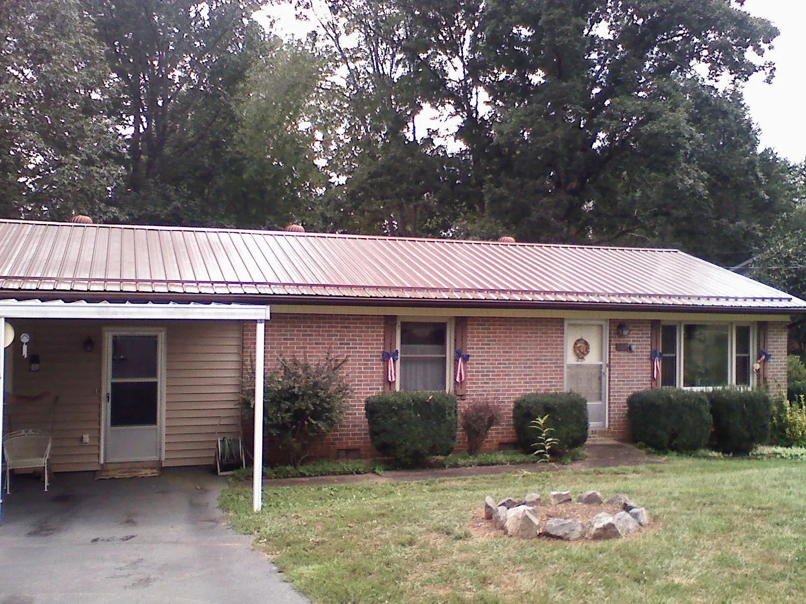 Bronze metal roof and carport on a brick ranch home — Roof Repair work by our crew in Schuylerville
